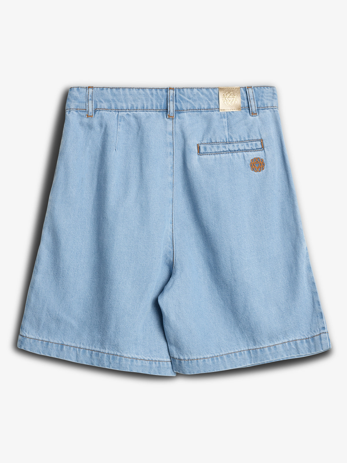 Een lichtblauwe spijkershort ligt op een neutrale achtergrond. De short heeft achterzakken met een klein logodetail en een merklabel op de tailleband.