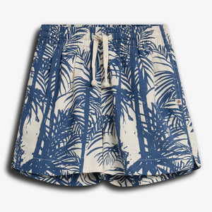 Een korte broek met een blauw en wit palmboompatroon, voorzien van een trekkoord in de tailleband. De broek ligt tegen een witte achtergrond.