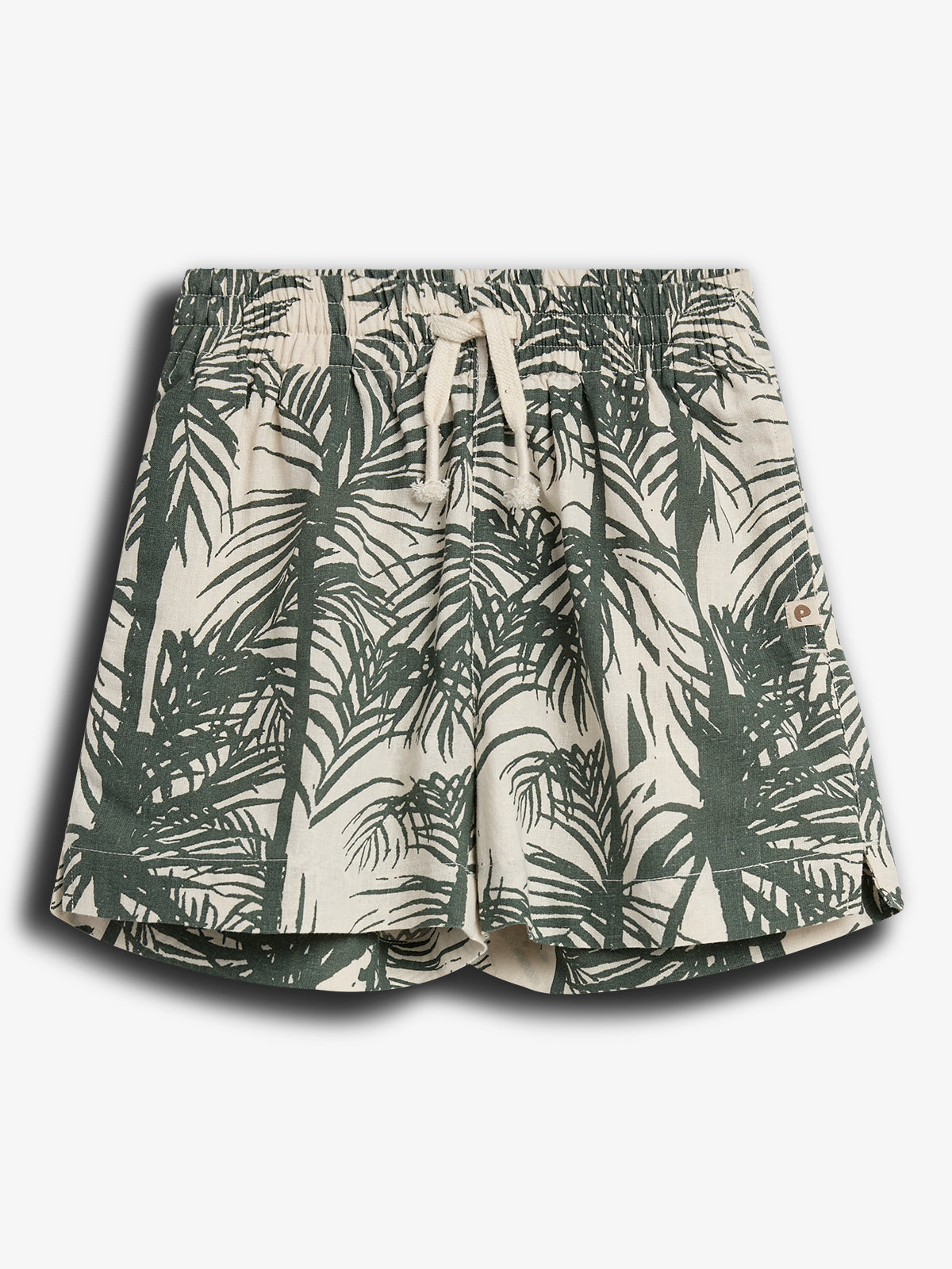 Een korte broek met een tropisch palmbladpatroon en trekkoord in een gestructureerde stof. De broek is voornamelijk beige met donkergroene prints. Afgebeeld op een effen witte achtergrond.