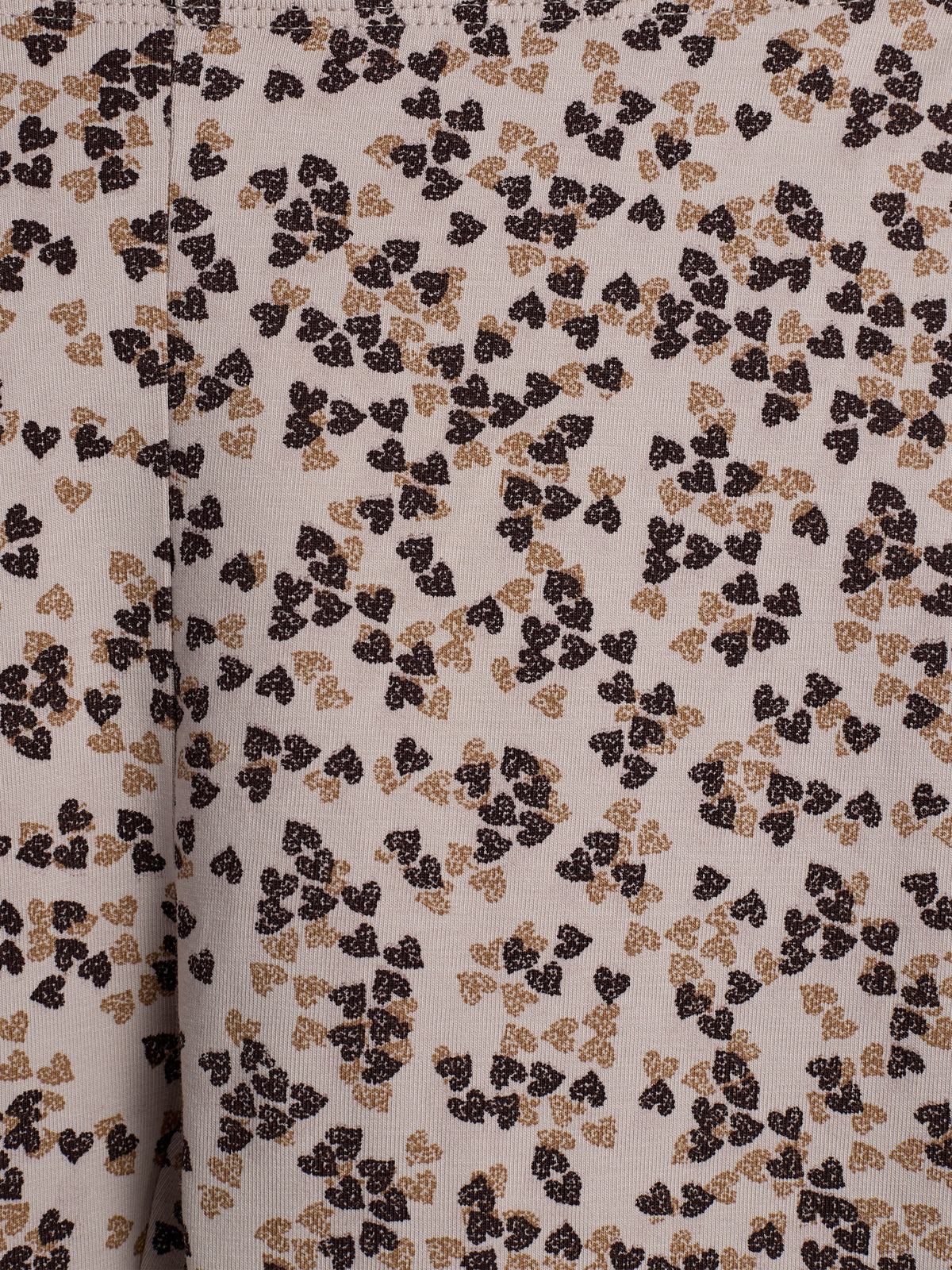 Stof heeft een patroon van verspreide, bruine en beige hartvormige blaadjes op een crème achtergrond. De blaadjes vormen kleine clusters, wat een speels en organisch uiterlijk creëert.