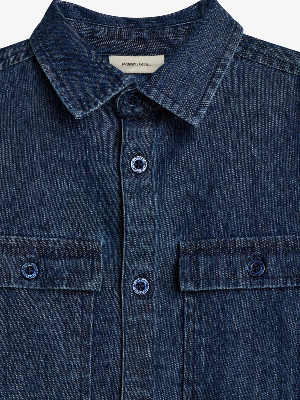 Denim shirt with buttoned pockets and a collar; "POPMULEX" on the label and "VSCOPOP" on the buttons; displayed against a plain white background.