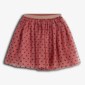 A pink tulle skirt with a gold waistband features a pattern of small black heart shapes scattered throughout. It is displayed against a plain white background.