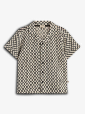 Short-sleeved shirt with a black and white checkered pattern, featuring black buttons and a collar, displayed against a plain white background.
