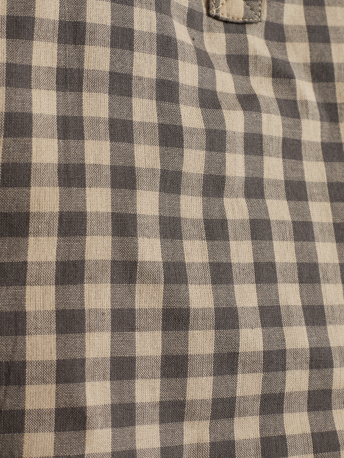 Stof met zwart-wit geruit patroon valt soepel, zonder zichtbare ontwerpen of tekst. De context suggereert een textielmateriaal, mogelijk kleding of decoratief gebruik.