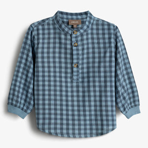 Een blauw geruite kinderblouse met lange mouwen en een ronde kraag heeft drie knopen aan de voorkant. Op het label staat "POMPDELUX" en "116". Geplaatst tegen een witte achtergrond.