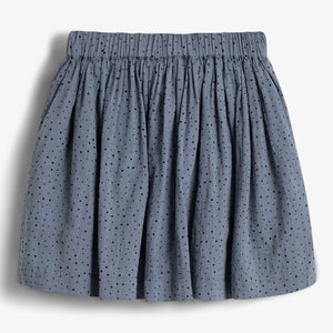 A blue, knee-length skirt with small black polka dots hangs loose, featuring an elastic waistband. It is displayed against a plain white background.