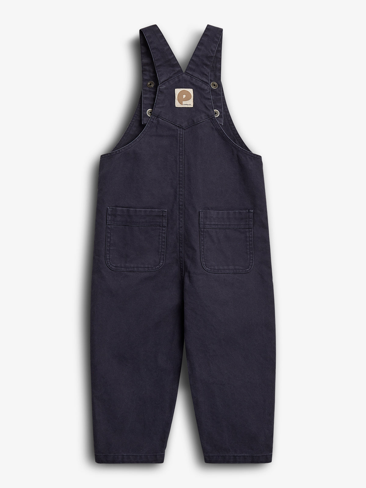 Donkerblauwe kinderoverall met verstelbare bandjes en twee voorzakken. Een bruin label met logo bevindt zich aan de bovenkant. De achtergrond is effen wit.