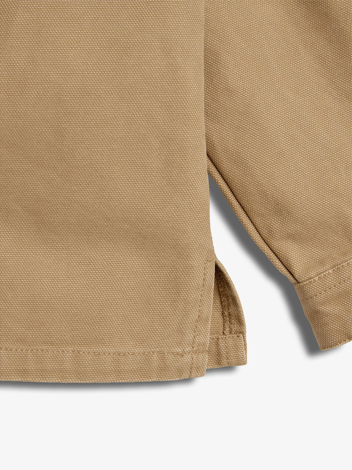 Beige fabric with a diagonal weave pattern; features a split seam detail at the bottom hem. The surrounding area is a plain, light background with no additional objects.