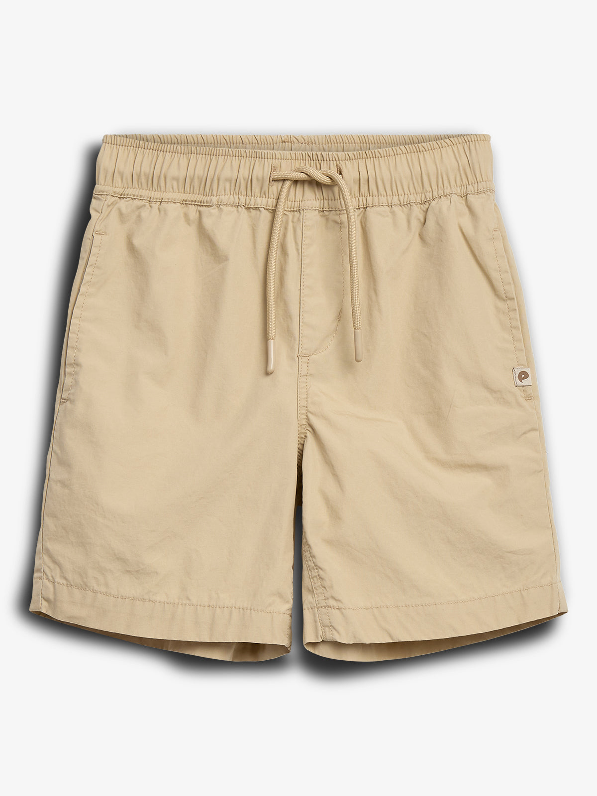 Beige korte broek met elastische tailleband en trekkoord, liggend voor een witte achtergrond. De broek heeft zijzakken en een klein logo-label aan de rechterkant.