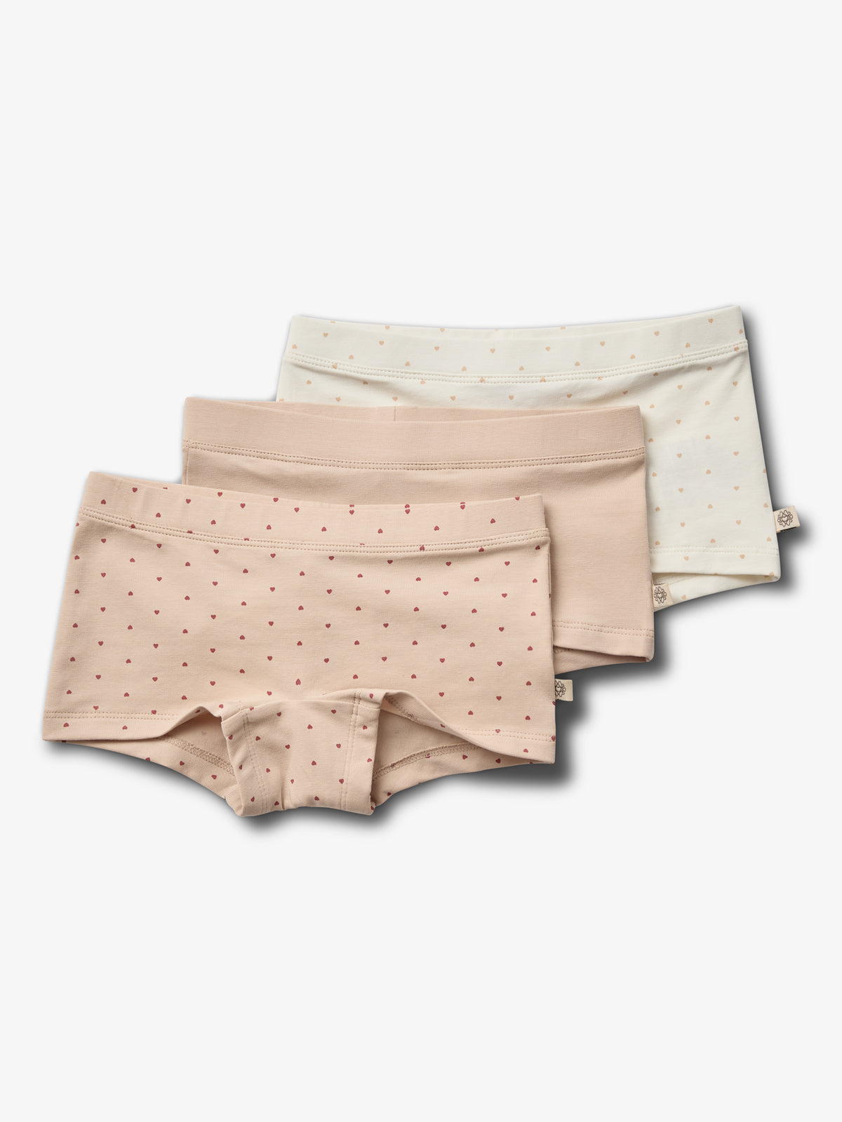 Drie paar kinderslips zijn opgestapeld. Ze zijn in pastelkleuren met kleine hartjesmotieven. De achtergronden zijn effen wit. De slips liggen op elkaar in een overlappende opstelling.