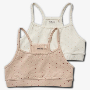 Twee gestippelde crop tops liggen gestapeld. De bovenste is crèmekleurig en de onderste roze. Beiden hebben dunne bandjes. De tekst "POMPdeLUX ORGANIC COTTON" staat erin.