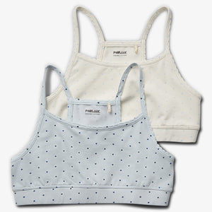 Twee kinderbeha's met smalle bandjes, één lichtblauw en één crème, beide met kleine hartjes. Tekst: "POMPdeLUX ORGANIC COTTON." Geïsoleerd op een witte achtergrond.