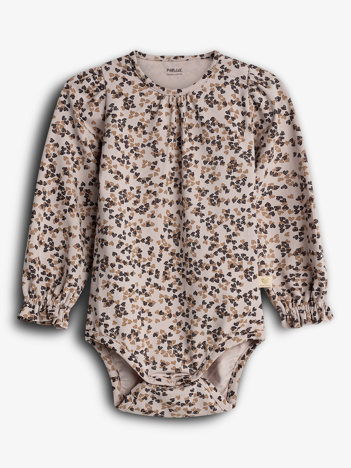 Een babyrompertje met een bloemenpatroon in zwart en bruin op een lichtroze achtergrond. Het heeft lange mouwen en ruches aan de polsen. Tekst: "Pomp de Lux Organic Cotton".