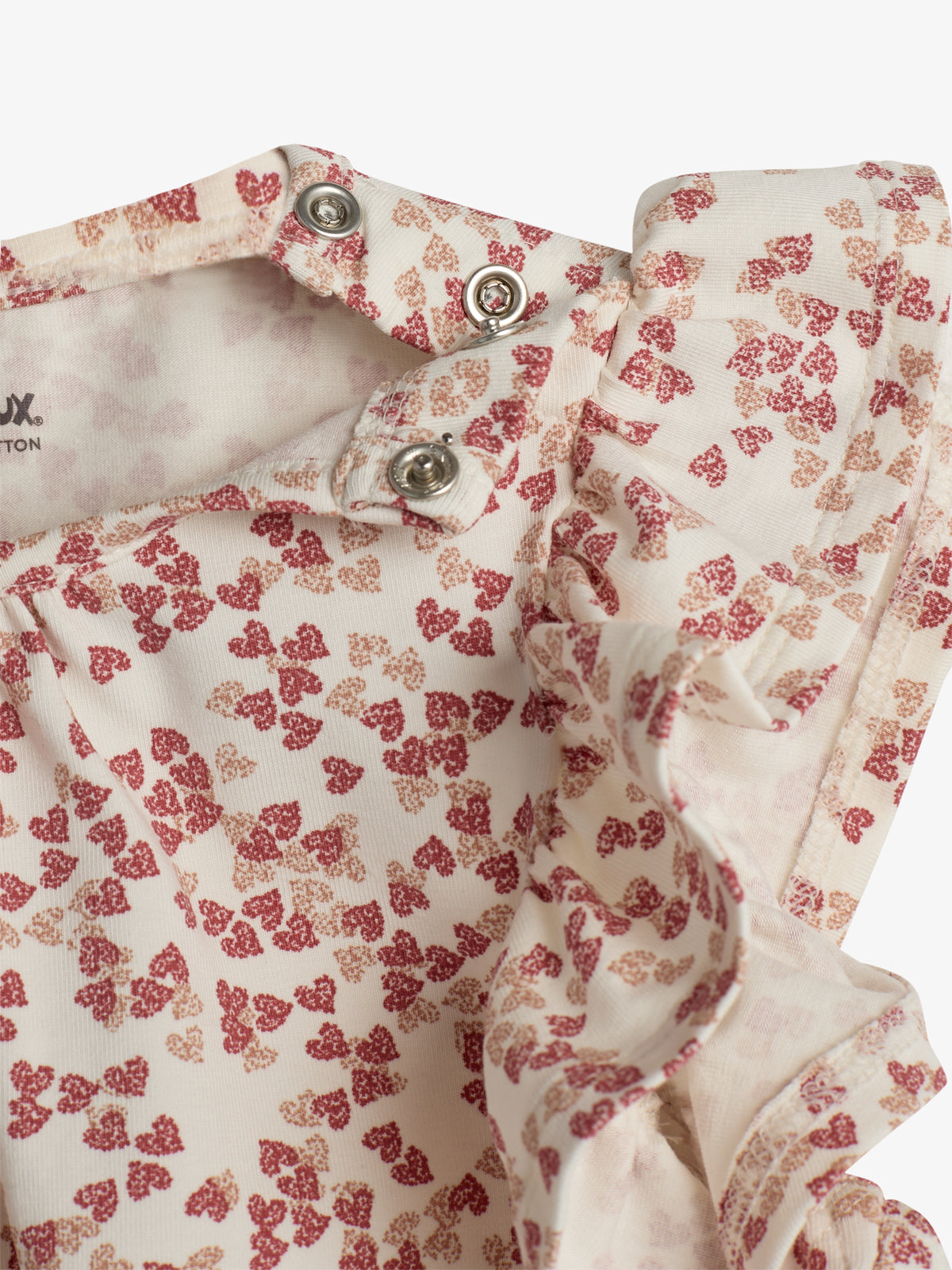 Een rompertje met rood-roze bloemenpatroon, sluiting met drukknoopjes. Draagbare kleding voor baby's. Witte achtergrond. Tekst: "Muzux", "COTTON".