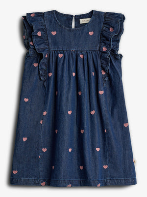 Denim jurk met roze hartjesmotief, gerimpelde mouwen, en een ronde hals, tegen een effen achtergrond. Etiket: "Paper + Cloth".
