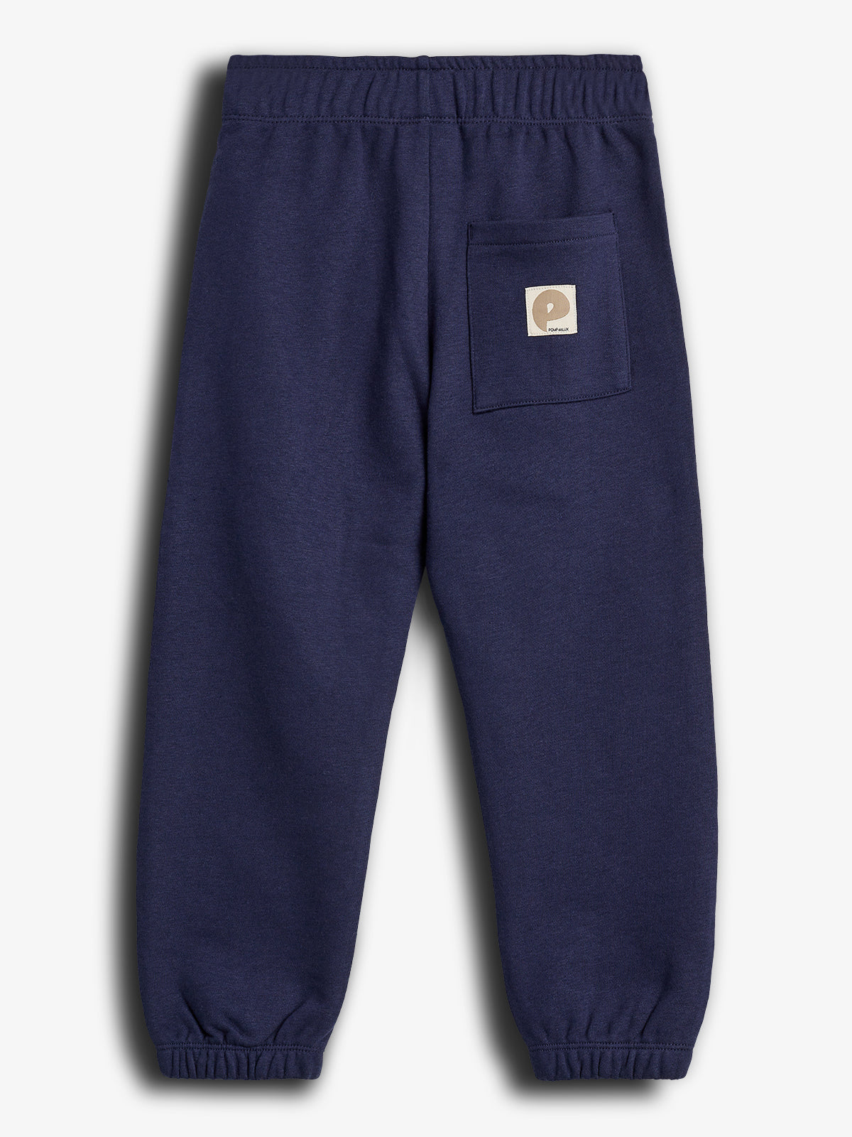 Dark blue sweatpants lie flat against a plain background, featuring an elastic waistband and cuffs. A square pocket with a beige label, reading "P Polarn O. Pyret," adorns the back.