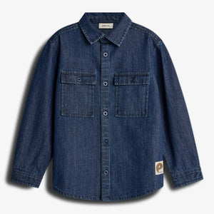 Denim shirt displayed, featuring long sleeves, buttoned front, and two chest pockets. Labels read "paperless" inside collar and logo tag on lower side. Set against a plain white background.