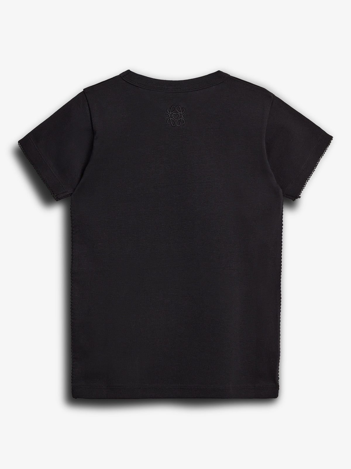 A black T-shirt is laid flat, displaying a subtle embroidered design near the neckline. The background is plain, emphasizing the garment's simplicity and texture.