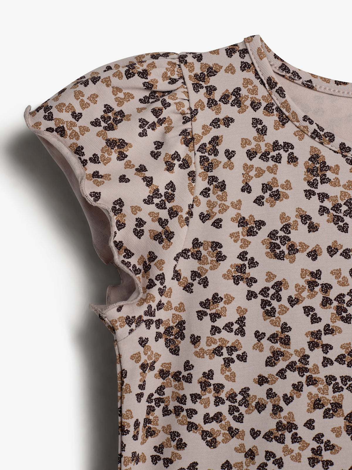 A short-sleeved shirt displays a pattern of small, dark brown and beige floral shapes. The fabric appears soft and textured, set against a plain white background.