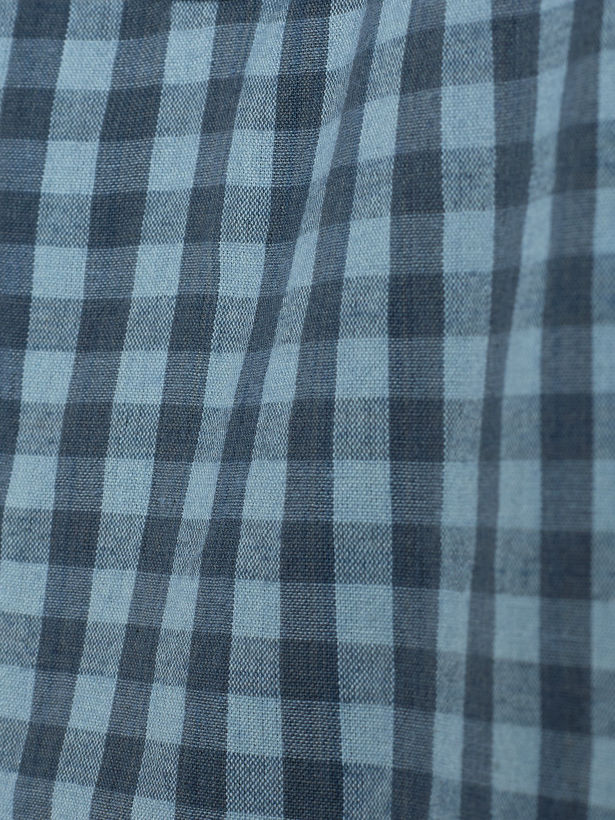 Stof vertoont een blauw geruit patroon met donkere en lichtere tinten. Het ontwerp is regelmatig en symmetrisch, typisch voor kleding of meubelbekleding.