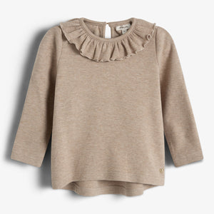 Beige trui met lange mouwen en ruches rond de hals, hangt tegen een witte achtergrond. Label binnenin met de tekst: "Milla Lou."