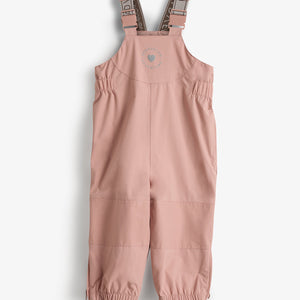Roze kinderregenbroek met verstelbare schouderbanden en elastische bretels, liggend op een witte achtergrond. Tekst op de borst: "TOG:0.5" en "MPD DELTA VOLVENTUM."