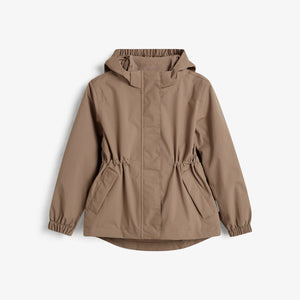 Jas hangt aan de muur, met een capuchon en elastische mouwen; beige kleur, vooraanzicht in een minimalistische studio-omgeving.