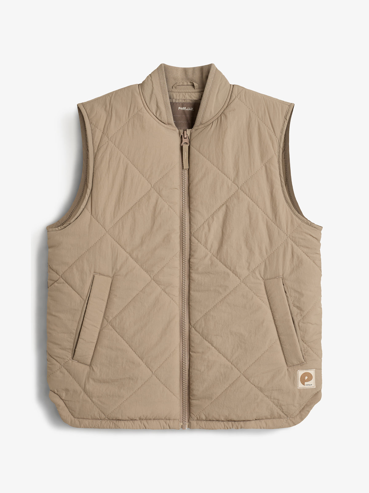 Een beige, gewatteerde bodywarmer met ruitenpatroon ligt plat. Het heeft een ritssluiting en twee zakken. Rechts onderaan bevindt zich een klein label met de letter "p".